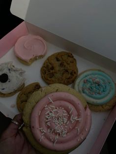 an open box filled with assorted cookies and doughnuts