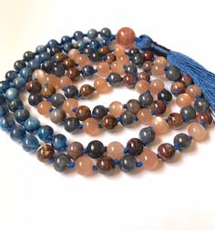 Kyanite Sunstone Pietersite Iolite 108 Mala Necklace Item Details: 30/6mm Kyanite 26/6mm Sunstone 26/6mm Pietersite 26/6mm Iolite 12mm Sunstone Guru Cotton Thread Handmade Rayon Silk Tassel Made with genuine natural material - only genuine material have the healing properties All my products are made with high quality beads from reliable sources and I take care to cleanse them and treat them with respect while I make the mala. Gemstones have their own vibrations, but also pick up energy as they Blue Round Beads Mala For Meditation, Blue Natural Stone Beads For Meditation, Blue Natural Stones Beads For Meditation, Blue Beads For Meditation, Holistic Multicolor Gemstone Beaded Necklaces, Holistic Multicolor Gemstone Beaded Necklace, Blue Gemstone Beads Mala As Gift, Multicolor Beaded Necklaces For Meditation, Multicolor Hand-strung Mala With Round Beads