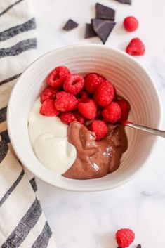 a bowl filled with chocolate pudding and raspberries