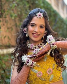 a woman in a yellow dress with flowers on her head and hands around her neck