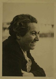 an old black and white photo of a woman smiling