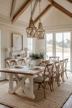 a dining room table and chairs in front of large windows