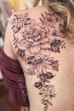 the back of a woman's shoulder with flowers on it