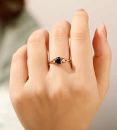 a woman's hand with a ring on it and a blue stone in the middle