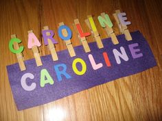 the name caroline spelled with wooden letters on a purple piece of paper that says caroline