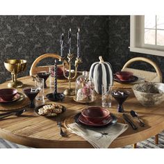 a wooden table topped with plates and bowls