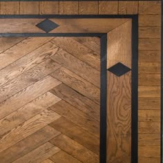 a wooden door with black trim and an arrow design on the bottom half of it