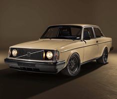 an old volvo wagon is shown in this image, it's light brown and has black rims