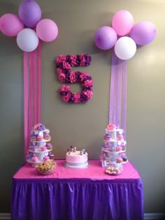 a table topped with lots of cake and balloons