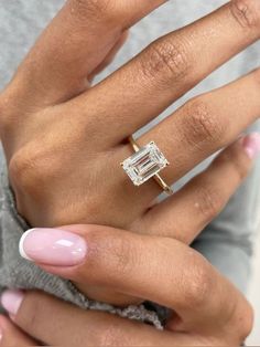 a woman's hand with a ring on it and a baguette in the middle