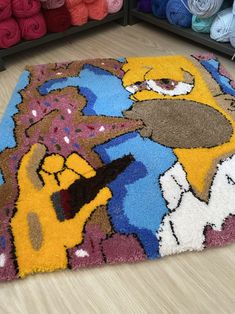 a rug with the simpsons characters on it in front of crochet yarns