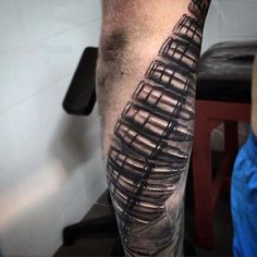 a man's leg with a black and grey tattoo design on the calf area