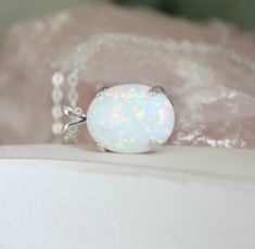 "Beautiful Large white lab-created opal pendant necklace. These gorgeous opals are very similar to natural mined opals. Lab-created opals contain 70-90% silica (from which natural opal is formed) and 10-30% resin. The resin makes the opal harder, stronger, unlike natural opals, which are known to be soft and fragile. Each opal displays a rainbow of color that sparkles with every catch of light. I've handset two different size opals in a solid sterling silver prong settings 16x12mm (5/8\" x 1/2\" White Opal Ring As A Gift, White Opal Ring For A Gift, White Opal Birthstone Jewelry, Elegant White Pink Opal Jewelry, White Ethiopian Opal Gemstone Jewelry, White Oval Opal Necklace, White Opal Round Pendant Necklace, White Opal Necklace For Gift, White Opal Jewelry Gift