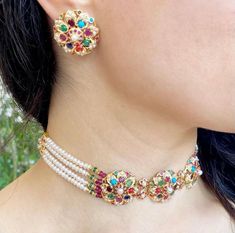 Featuring a navratna choker in 22ct gold with studs earrings. The choker weighs 30.98 GMs including 8 GMs of stringing beads. The earrings weigh 11.35 GMs Multicolor 22k Gold Jewelry With Cutdana, Multicolor 22k Gold Cutdana Jewelry, Multicolor Cutdana 22k Gold Jewelry, Multicolor Round Choker For Festive Occasions, Multicolor Temple Jewelry Choker For Ceremonial Occasions, Ceremonial Multicolor Temple Jewelry Choker, Festive Temple Jewelry Choker With Round Beads, Navratna Choker, Jadau Choker