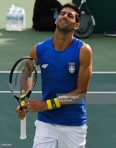 a man holding a tennis racquet on top of a tennis court