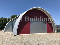 a red and white building with a large metal door on the side of it's roof