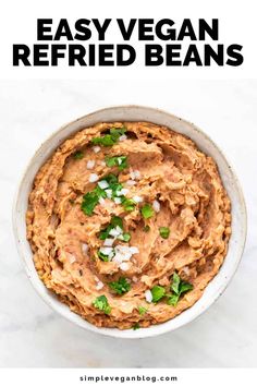 a bowl filled with vegan refried beans and garnished with cilantro