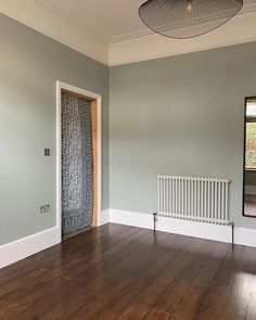 an empty room with hard wood floors and a radiator