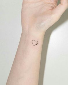 a small heart tattoo on the wrist