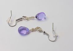 These exquisite handmade earrings feature stunning purple teardrop glass beads that dangle delicately from silver ear wires. The vibrant purple hue of the beads adds a pop of color to any outfit, making these earrings perfect for both casual and formal occasions. The teardrop shape effortlessly captures the light, creating a beautiful and eye-catching sparkle. Whether you're looking for a unique addition to your own jewelry collection or a special gift for someone dear, these purple teardrop glass bead earrings are sure to impress. To help prolong the life of your jewelry remove before any water activities and avoid direct contact with perfumes, lotions, hairsprays etc. Purple Hues, Handmade Earrings, Beaded Earrings, Special Gifts, Color Pop, Jewelry Earrings Dangle, Glass Beads, Jewelry Collection, Dangle Drop Earrings