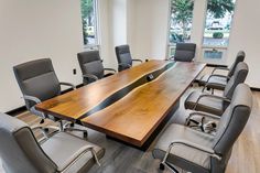 an empty conference room with chairs and a large wooden table in the middle of it