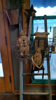 two stuffed animals sitting on top of a ladder