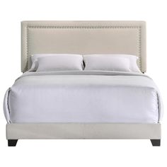 a bed with white linens and pillows on top of the headboard is shown