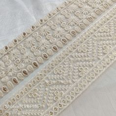 "**Buy this product in combine with other item to lower shipping cost per item. ** This listing for white viscose cotton Thread and sequins Embroidery trim by the yard. This is a beautiful embroidery trim embroidered with white thread and sequins work on fabric Net fabric. **Dimension** Width: Approx. 6 cm (2.5\")(Refer photo) Total Length: 1 Yard ( 36\") Color option : Natural white ( Refer Photo) This beautiful Lace can be used for designing stylish blouses, shrugs, skirts, tunics, festive wea Festive Bohemian White Embroidered Fabric, White Embroidered Cotton Fabric With Motifs, White Cotton Embroidered Fabric With Motifs, Festive White Embroidered Fabric With Handwork, Festive White Embroidered Handwork Fabric, Festive White Handwork Embroidered Fabric, Traditional White Embroidered Fabric With Handwork, White Bohemian Embroidered Fabric For Festivals, White Bohemian Embroidered Fabric With Motifs