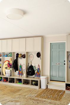 a room filled with lots of different items on the wall and in front of a blue door