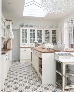 a kitchen with white cabinets and tiled floors