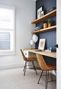 a home office with two chairs and a desk in front of a window that has shutters on both sides