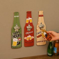 three beer bottle openers are hanging on the wall