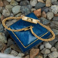 This fantastic vintage Chopard wristwatch (Model No. 5145) features an 18K yellow gold case and bracelet. The case measures 24mm X 14.5mm X 6.3mm. The case is accented with thirty-eight (38) bead set, round brilliant cut diamonds. The back of the case is engraved with the following reference number: SG3810, 171489, 5145. The dial color is champagne and is signed Chopard GENEVE. The movement is a Chopard manual wind, 17 jewel movement. The 18K yellow gold woven style bracelet is finished with a fold- over clasp. The clasp is accented with one (1) bead set, round single cut diamond. The watch fits up to a 6.75 inch wrist. The watch currently ticks as of writing this, but that can change. We do not offer any warranty on watch movements. Timeless Jubilee Bracelet Watch Accessory As Gift, Timeless Jubilee Bracelet For Watches As A Gift, Gold Evening Watch With Jubilee Bracelet, Antique Yellow Gold Watch Bands For Formal Occasions, Elegant Yellow Gold Watch Accessories With Jubilee Bracelet, Elegant Yellow Gold Jubilee Watch Bracelet, Vintage Yellow Gold Watches With Diamond Hour Markers, Gold Rectangular Watch With Jubilee Bracelet, Timeless Yellow Gold Watch With Jubilee Bracelet