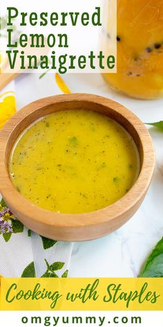 a wooden bowl filled with soup next to a jar of lemon vinaigrette