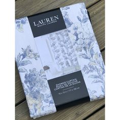 the packaging for lauren's bed linens is displayed on a wooden table with white and blue flowers