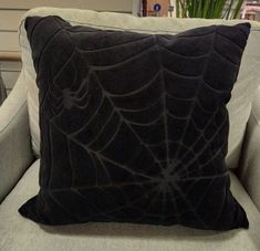 a black spider web pillow sitting on top of a couch