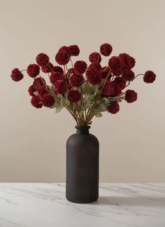 a vase filled with red flowers on top of a table