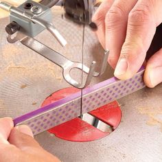 a person is working on some type of metal object with scissors and pliers in their hands