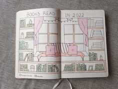 an open book with a drawing of a bed and bookshelf in it on a table