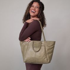 This bag has everything you want in a tote top zip closure, a padded tech pocket, solid leather straps, and Sheilas signature circular handles that fold down when not in use Sheila EastWest Tote In Metallic Leather  Burnished Sage TOTE Bag in Sage Green | Hobo® Versatile Satchel With Round Handle For Daily Use, Chic Weekender Bag With Removable Pouch And Top Handle, Versatile Satchel With Round Handle For On-the-go, Modern Weekender Shoulder Bag With Detachable Handle, Modern Weekender Bag With Detachable Double Handle, Shopping Weekender Bag With Detachable Handle, Chic Weekender Bag With Detachable Handle, Chic Everyday Weekender Bag With Detachable Handle, Weekender Bag With Detachable Handle