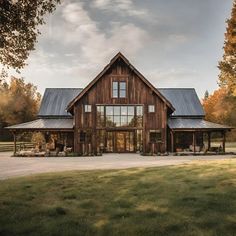 a large wooden house sitting on top of a lush green field