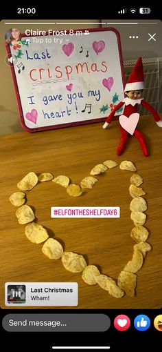 an elf is making a heart shape made out of crackers on a table with a sign that says last christmas i have you my heart?