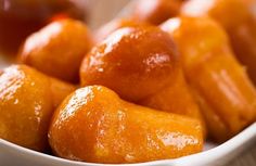 a white bowl filled with oranges on top of a table