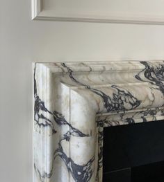 a marble fireplace surround with black and white paint