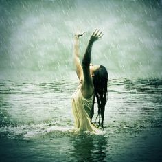 a woman standing in the water with her hands up to her head, saying i thirst for god, the living god