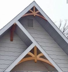 the front of a house with an arched window and wood trim on it's side