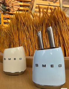 two toasters sitting next to each other on top of a wooden table with straw in the background