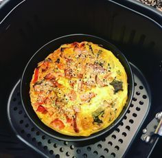 an omelet sitting on top of a black grill pan in the middle of a table