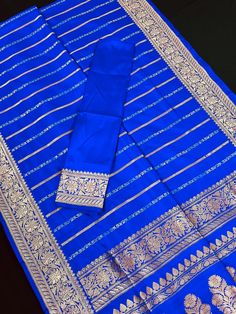 SILK MARK CERTIFIED !!Gorgeous Pure Katan Royal Blue Color with Copper and Slier Zari Work. Strips Sarees in Copper and Sliver Zari with Floral Buttas on the Pallu Soft, light weight and easy to drape Saree. The Strips are dense towards the pallu and get scattered the other end. Item : SareeColor : Royal Blue ColorBase Fabric : Pure Katan Silk Blouse piece : Comes with Blouse pieceBlouse material : Pure Katan SilkFall & Edging (Yes/No) : YesComes with Silk Mark Certificate (Yes/No) : Yes Disclai Banarasi Katan Silk Saree, Katan Silk Saree, Men's Ethnic Wear, Drape Saree, Bandhani Saree, Katan Silk, Kanjivaram Sarees, Readymade Blouse, Zari Work