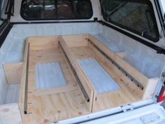 the back end of a white truck with wooden steps